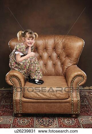 Girl sitting in armchair View Large Photo Image Stock Image - Girl sitting in armchair. Fotosearch