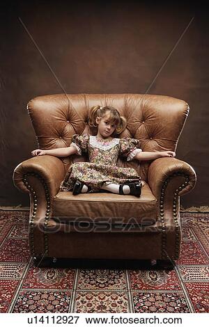 Girl sitting in large armchair View Large Photo Image Stock Photo - Girl sitting in large armchair. Fotosearch