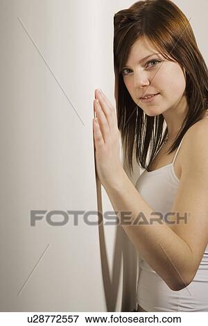 Girl standing against a wall View Large Photo Image Stock Photo - Girl standing against a wall. Fotosearch