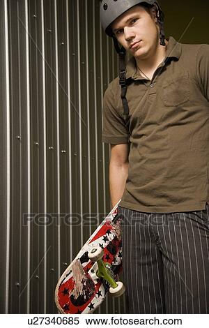 Stock Photography - Guy holding a skateboard. Fotosearch