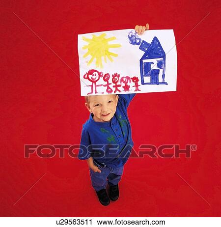 Stock Image - High angle view of a boy showing his painting at camera. Fotosearch