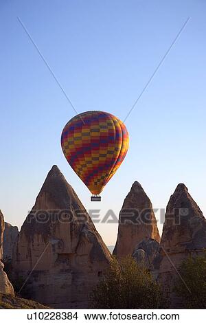 Hot air balloon flying over Goreme valley, Cappadocia, Anatolia, Turkey View Large Photo Image Picture - Hot air balloon flying over Goreme valley, Cappadocia, Anatolia, Turkey . Fotosearch