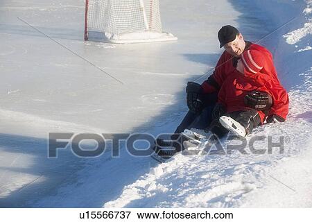 Stock Photo - Ice hockey players sitting on snow. Fotosearch