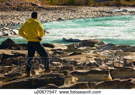 Stock Photo - Man overlooking a mountain river . Fotosearch