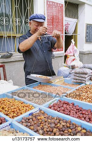 Stock Photo - Man selling nuts and dried fruit in Dunhuang, China. Fotosearch