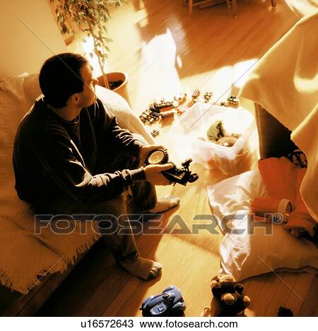 Man surrounded by child's toys View Large Photo Image Stock Image - Man surrounded by child's toys. Fotosearch