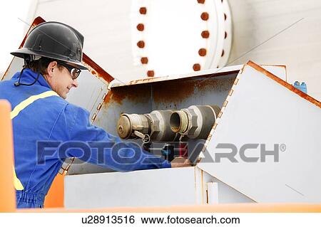 Man working on oilfield machinery View Large Photo Image Stock Photograph - Man working on oilfield machinery. Fotosearch