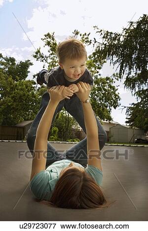 Mother playing with son on trampoline View Large Photo Image Stock Photo - Mother playing with son on trampoline. Fotosearch