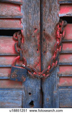 Stock Image - Padlock and chain on wooden door. Fotosearch