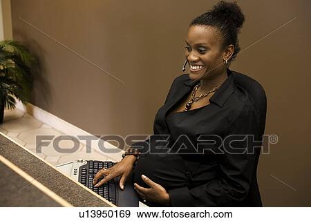 Stock Photo - Pregnant woman at work. Fotosearch