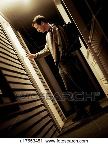 Stock Image - Side view of a man ringing bell. Fotosearch