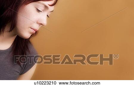 Stock Image - Side view of a sad woman. Fotosearch