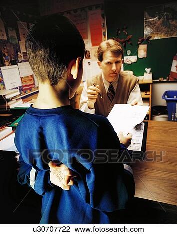 Stock Image - Student getting in trouble with teacher. Fotosearch