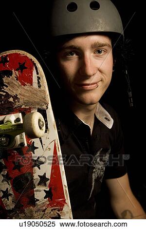 Studio shot of a man with a skateboard View Large Photo Image Stock Photography - Studio shot of a man with a skateboard. Fotosearch