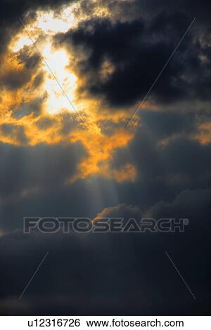 Sun piercing through clouds View Large Photo Image Stock Photograph - Sun piercing through clouds. Fotosearch