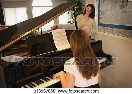 Teenage daughter playing the piano for her mother View Large Photo Image Stock Image - Teenage daughter playing the piano for her mother. Fotosearch