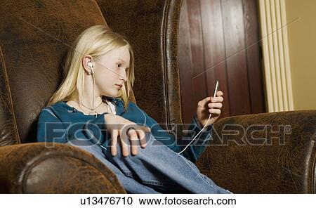 Stock Image - Teenage girl listening to music. Fotosearch