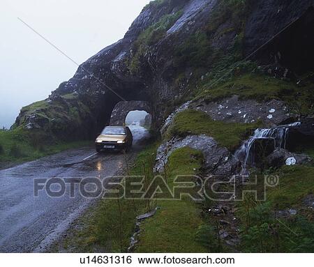 Stock Photograph - Touring, Rock tunnel between Glengarriff and Kenmare, Ireland. Fotosearch