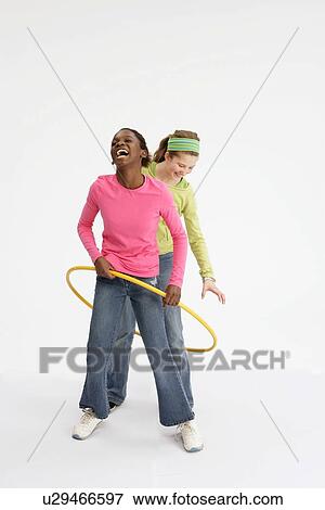 Two girls playing with hula hoop View Large Photo Image Stock Photo - Two girls playing with hula hoop. Fotosearch