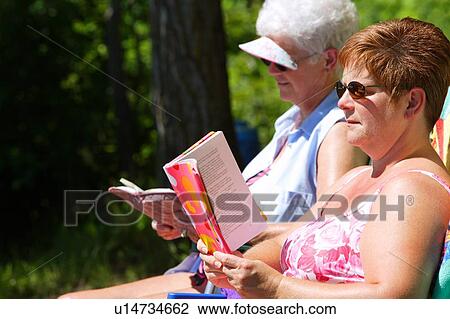 Two woman reading and sunbathing View Large Photo Image Stock Image - Two woman reading and sunbathing. Fotosearch