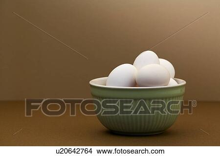 White eggs in green bowl on brown table View Large Photo Image Picture - White eggs in green bowl on brown table. Fotosearch
