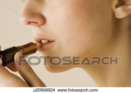 Picture - Woman applying lipstick. Fotosearch