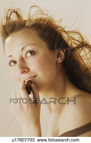 Woman applying lipstick View Large Photo Image Stock Image - Woman applying lipstick. Fotosearch