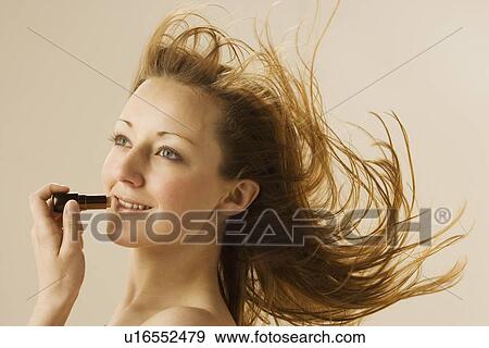 Stock Photo - Woman applying lipstick. Fotosearch