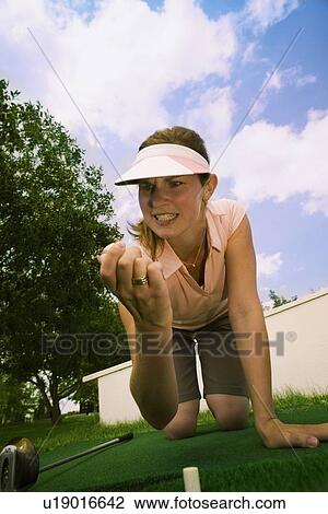 Stock Image - Woman holding golf ball. Fotosearch