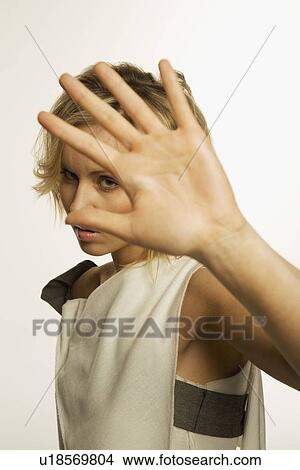 Woman holding her hand up and glaring View Large Photo Image Picture - Woman holding her hand up and glaring. Fotosearch
