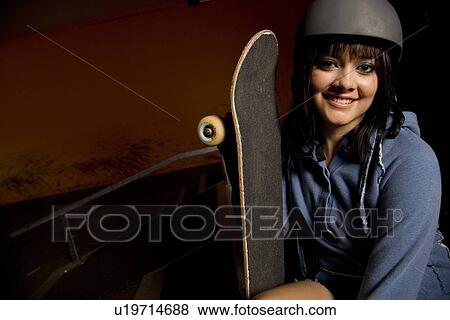 Woman holding skateboard View Large Photo Image Stock Photo - Woman holding skateboard. Fotosearch