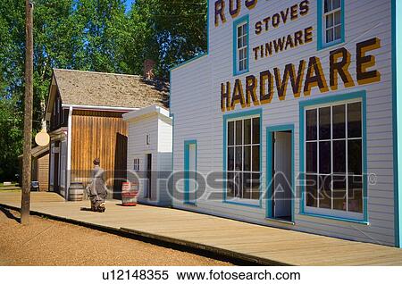 Woman in period dress walking past historic hardware store at Fort Edmonton Park View Large Photo Image Stock Photography - Woman in period dress walking past historic hardware store at Fort Edmonton Park . Fotosearch