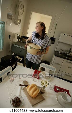 Stock Image - Woman in the kitchen on the phone. Fotosearch