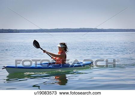 Stock Image - Woman kayaking. Fotosearch