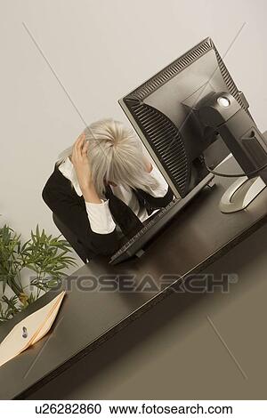 Woman sitting with head down in office View Large Photo Image Stock Image - Woman sitting with head down in office. Fotosearch