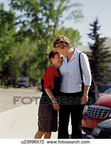 Woman smiling and hugging son View Large Photo Image Stock Image - Woman smiling and hugging son. Fotosearch