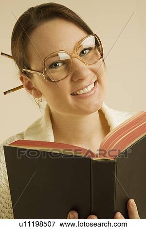 Stock Photo - Woman smiling and reading book. Fotosearch