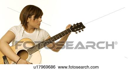 Woman tuning a guitar View Large Photo Image Stock Photograph - Woman tuning a guitar. Fotosearch