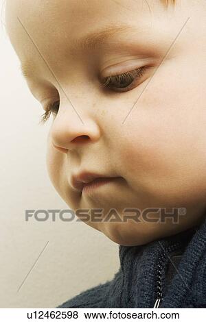 Stock Photo - Young boy looking down. Fotosearch