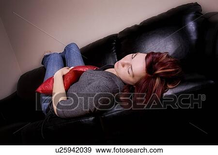 Stock Photo - Young woman sleeping on the couch. Fotosearch