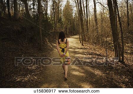 Young woman walking along a path View Large Photo Image Stock Photo - Young woman walking along a path. Fotosearch
