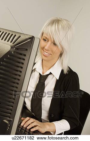 Young woman working at computer View Large Photo Image Stock Image - Young woman working at computer. Fotosearch