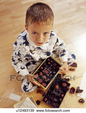 Boy into box of chocolates View Large Photo Image Stock Photo - Boy into box of chocolates. Fotosearch