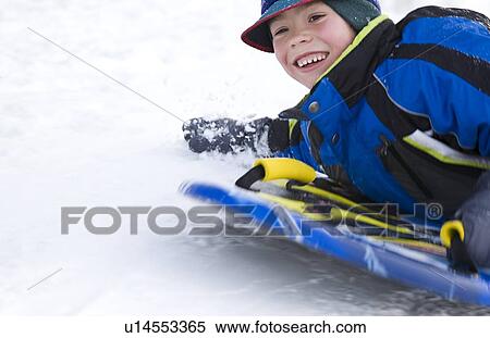 Stock Photography - Boy on a sled. Fotosearch