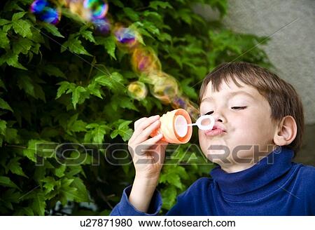 Stock Image - Boy playing with bubbles. Fotosearch