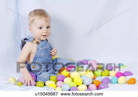 Stock Photo - Boy sitting with easter eggs. Fotosearch