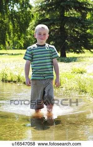 Boy standing in the water View Large Photo Image Stock Photo - Boy standing in the water. Fotosearch