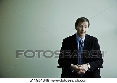 Stock Photo - Businessman sitting in chair. Fotosearch
