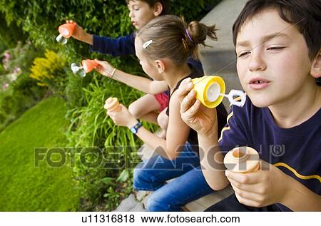 Children blowing bubbles View Large Photo Image Stock Photo - Children blowing bubbles. Fotosearch
