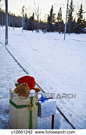 Stock Image - Christmas presents beside a snow-covered road. Fotosearch